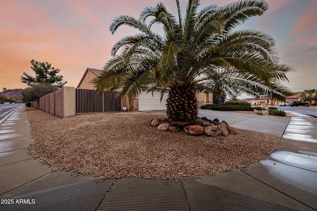 exterior space with a garage, concrete driveway, fence, and a gate