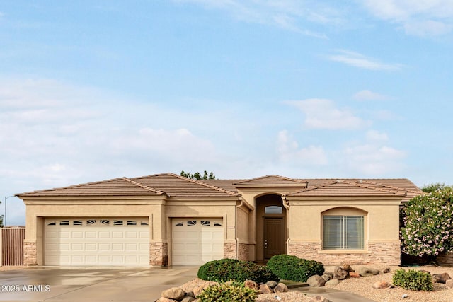 view of front of property featuring stone siding, stucco siding, an attached garage, and concrete driveway