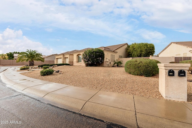 view of front of property featuring a garage, fence, and stucco siding