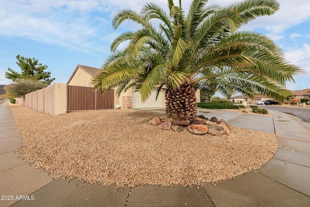 exterior space with fence, a gate, and stucco siding