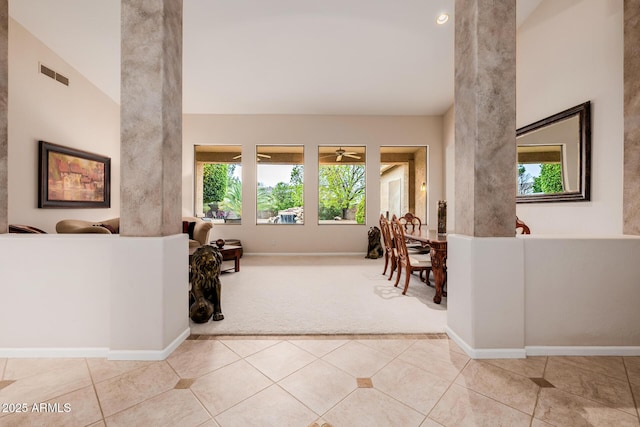 interior space with a towering ceiling, carpet, visible vents, and baseboards