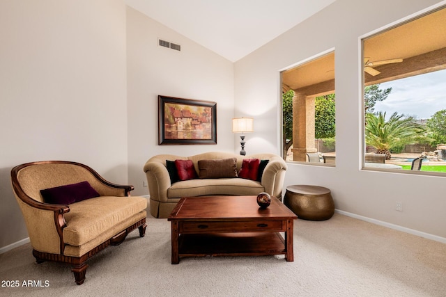 sitting room with baseboards, visible vents, vaulted ceiling, and light colored carpet