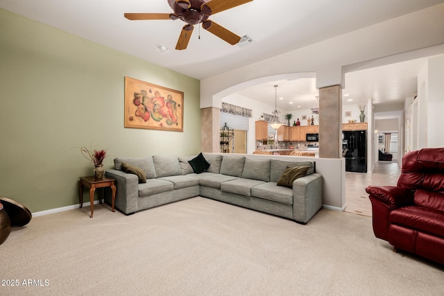 living room with a ceiling fan, light colored carpet, visible vents, and baseboards