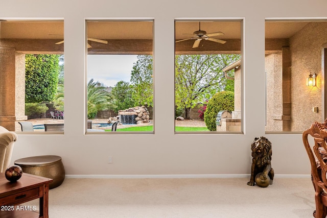 living area featuring carpet, ceiling fan, and baseboards