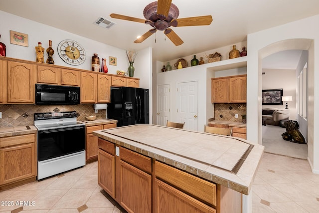 kitchen with black appliances, visible vents, tile counters, and light tile patterned flooring