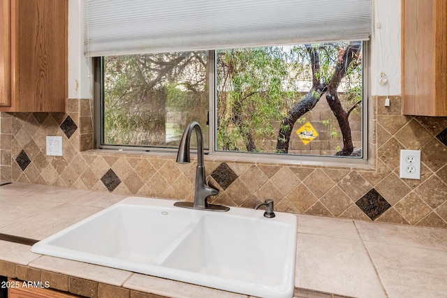 interior space featuring brown cabinetry, a sink, and tile counters