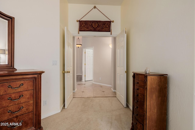 corridor featuring light carpet and baseboards