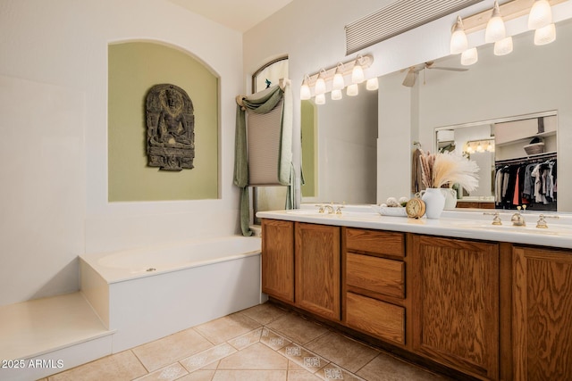 full bathroom featuring double vanity, a sink, a bath, and tile patterned floors