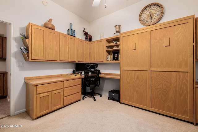 home office with ceiling fan, baseboards, light colored carpet, and built in study area