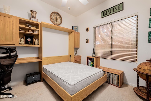 bedroom with lofted ceiling, built in study area, and light colored carpet