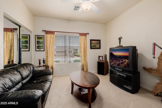 carpeted living area featuring ceiling fan, visible vents, and baseboards