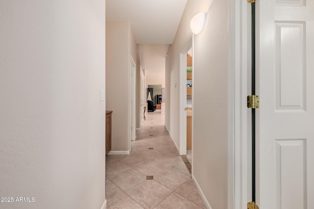 hallway featuring baseboards and light tile patterned floors