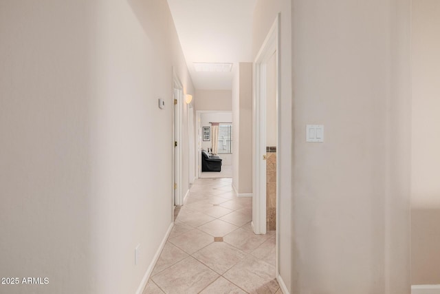 hall with light tile patterned floors and baseboards