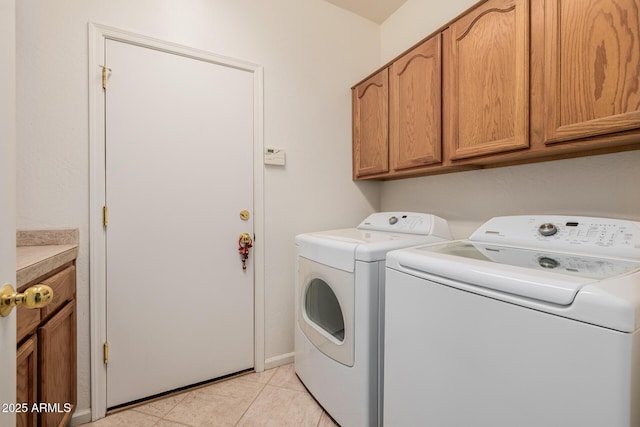 laundry room with light tile patterned flooring, cabinet space, and separate washer and dryer