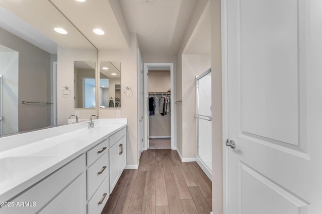 bathroom featuring wood-type flooring, vanity, and walk in shower