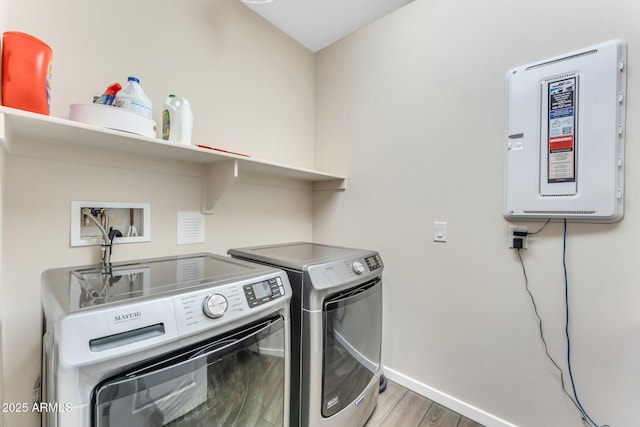 clothes washing area with separate washer and dryer and light wood-type flooring