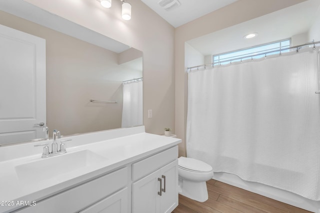 full bathroom featuring hardwood / wood-style flooring, vanity, shower / bathtub combination with curtain, and toilet