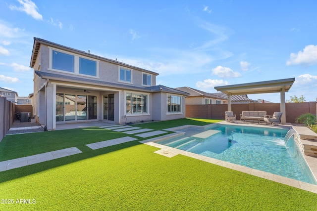 back of house with an outdoor living space, a yard, pool water feature, and a fenced in pool