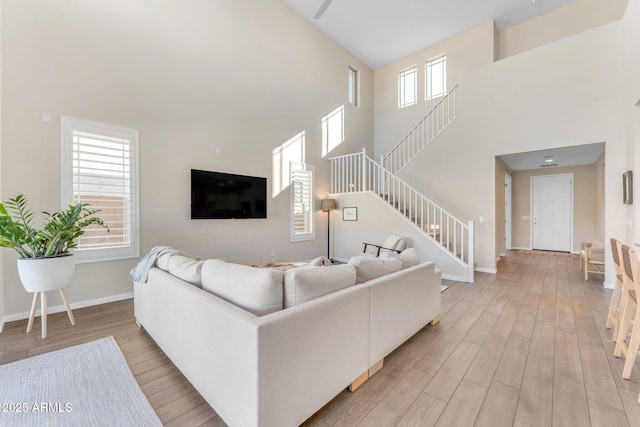 living room featuring a towering ceiling and light hardwood / wood-style floors