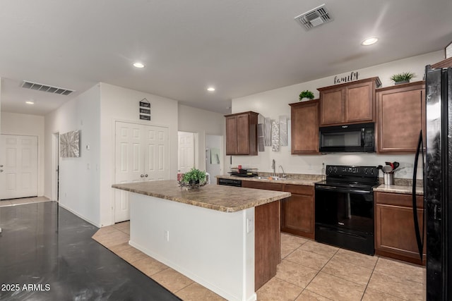 kitchen featuring light tile patterned flooring, sink, a kitchen island, and black appliances