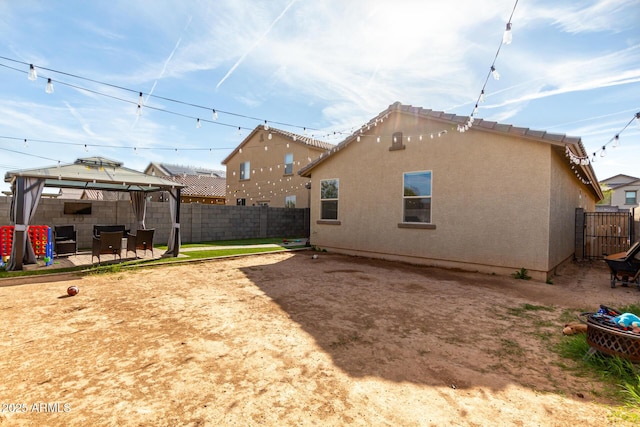 back of house with a gazebo and a patio