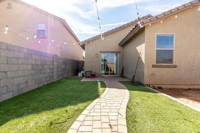 rear view of property with a lawn and a patio