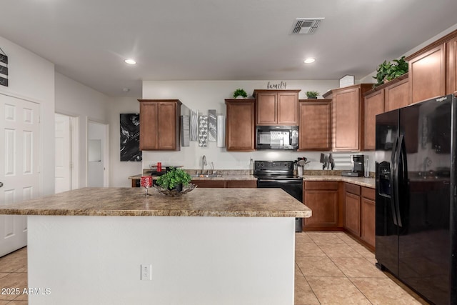 kitchen with sink, light tile patterned floors, black appliances, and a center island