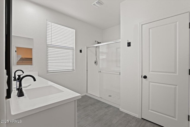 bathroom featuring vanity, hardwood / wood-style floors, and an enclosed shower