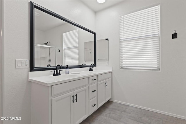 bathroom with hardwood / wood-style flooring, vanity, and a shower with shower door