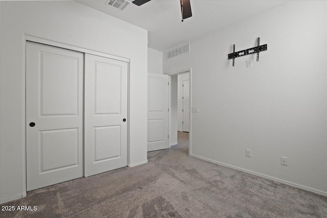 unfurnished bedroom with light carpet, a closet, and ceiling fan