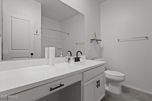 bathroom with vanity, wood-type flooring, toilet, and a shower