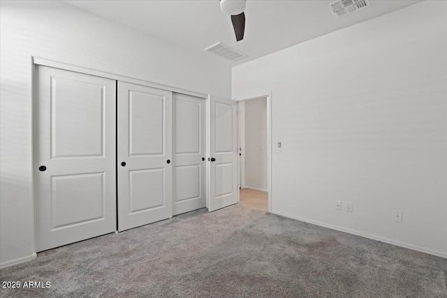 unfurnished bedroom with light carpet, a closet, and ceiling fan