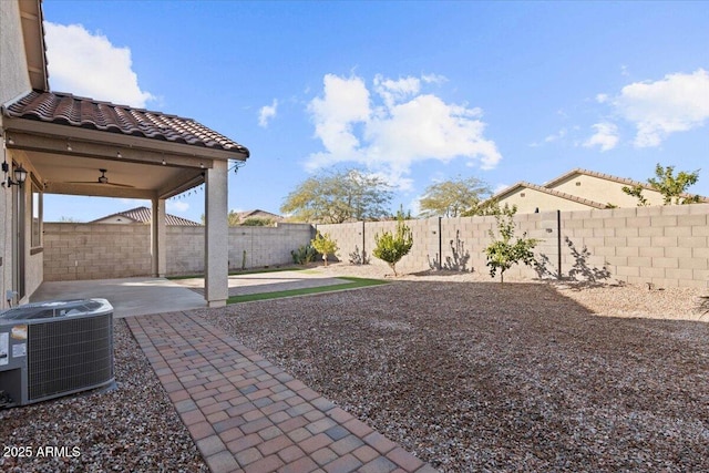 view of yard featuring ceiling fan, central AC unit, and a patio