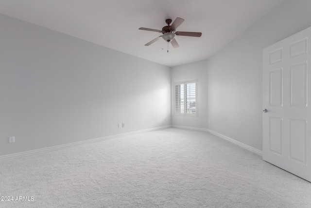 carpeted spare room featuring ceiling fan