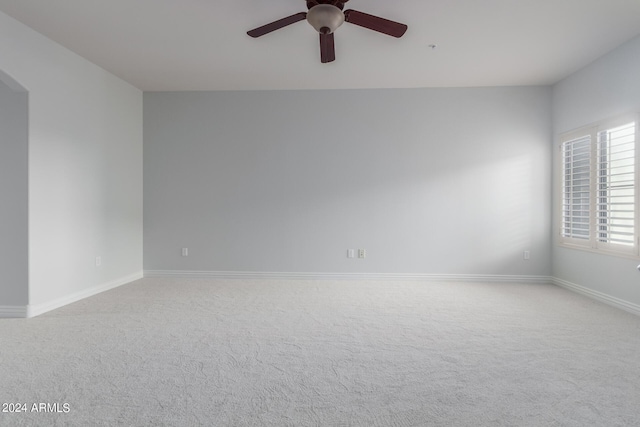 empty room with ceiling fan and light carpet