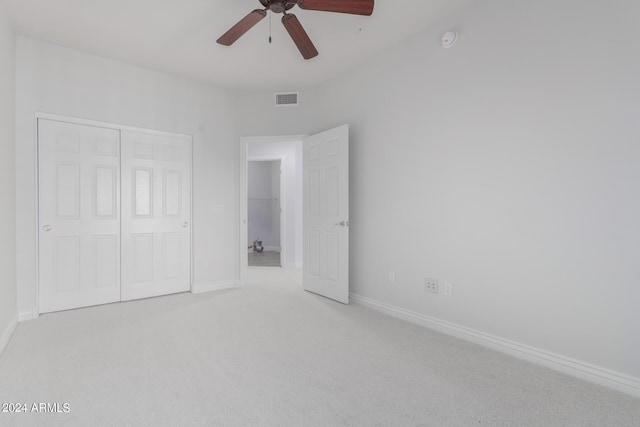 unfurnished bedroom with ceiling fan, a closet, and light colored carpet