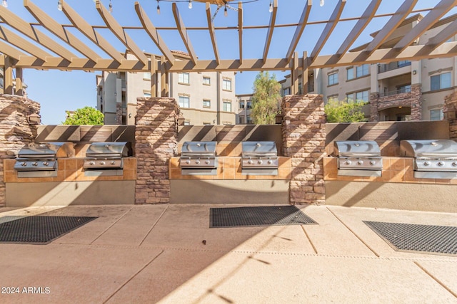 view of property's community featuring an outdoor kitchen and a pergola