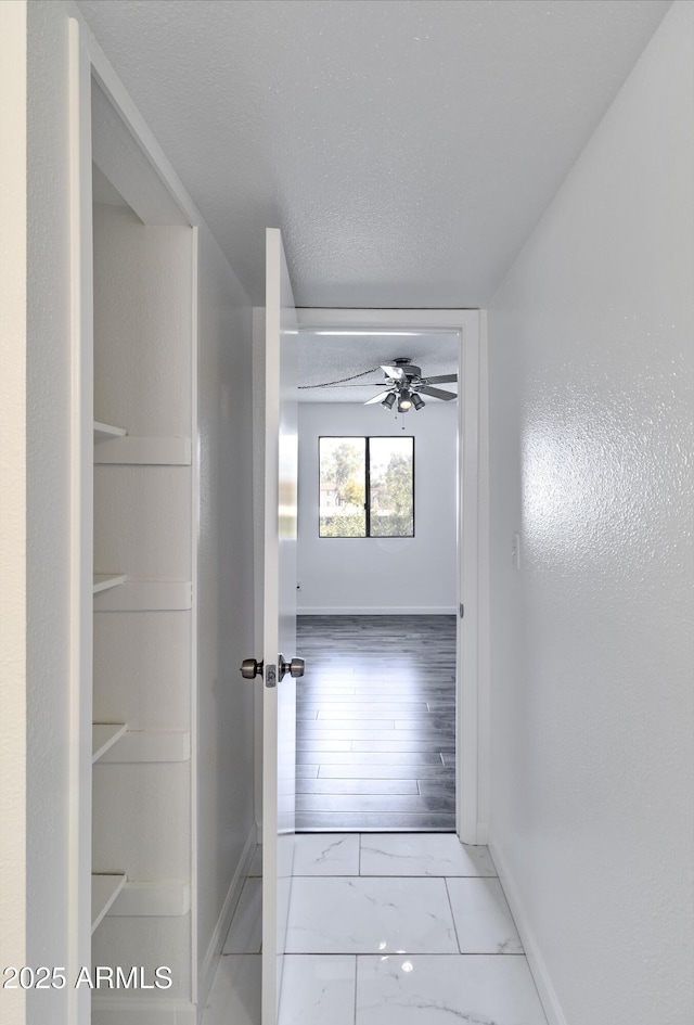 hallway with a textured ceiling