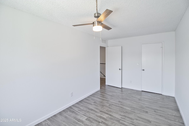 unfurnished bedroom featuring ceiling fan, hardwood / wood-style floors, and a textured ceiling