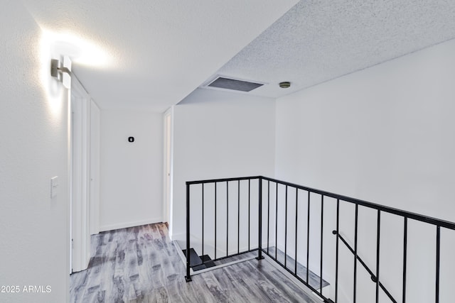 hall featuring a textured ceiling and light wood-type flooring