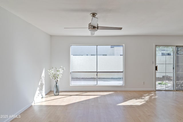 empty room with light hardwood / wood-style flooring, a wealth of natural light, and ceiling fan