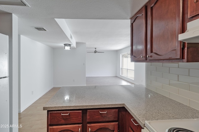 kitchen with light hardwood / wood-style flooring, ceiling fan, range, light stone counters, and a textured ceiling