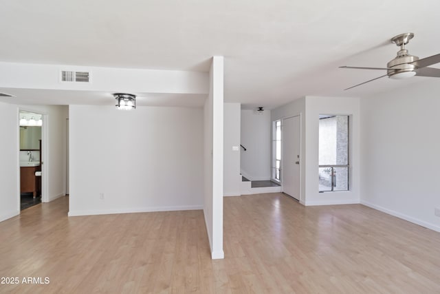 unfurnished room with sink, ceiling fan, and light wood-type flooring