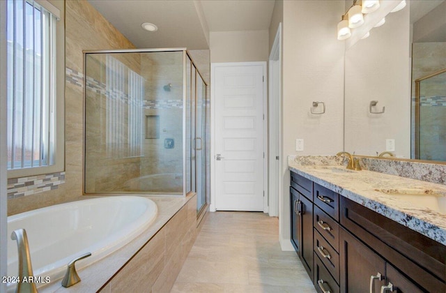 bathroom with shower with separate bathtub, plenty of natural light, and vanity