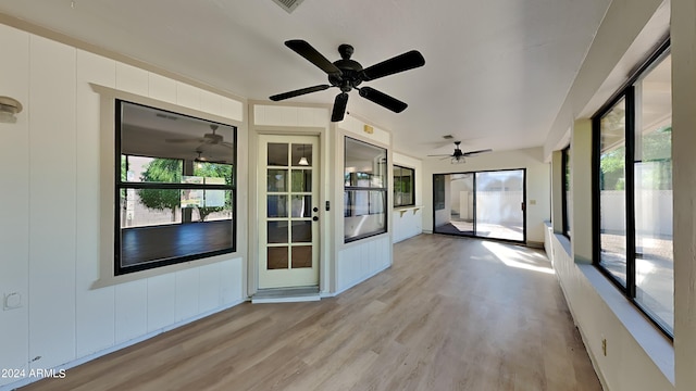 unfurnished sunroom featuring ceiling fan