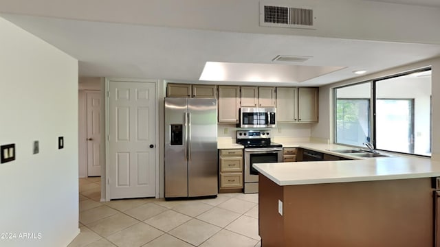 kitchen with kitchen peninsula, sink, light tile patterned floors, and appliances with stainless steel finishes