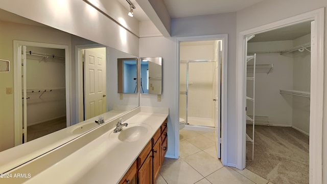 bathroom featuring tile patterned floors, vanity, toilet, and an enclosed shower