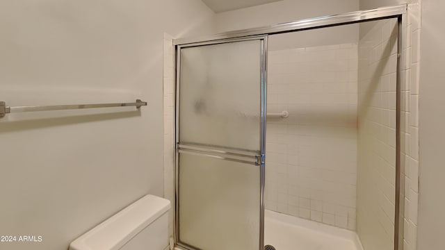 bathroom with toilet and a shower with shower door