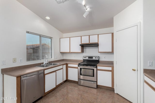 kitchen featuring appliances with stainless steel finishes, white cabinetry, lofted ceiling, sink, and rail lighting