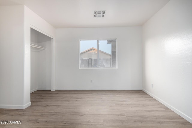 unfurnished bedroom featuring a closet and light hardwood / wood-style flooring